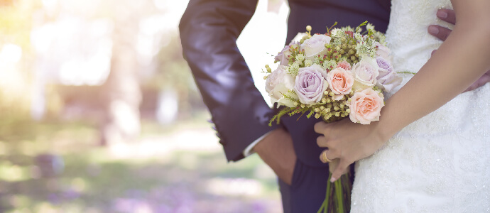 Bride holding bouquet of flowers next to groom