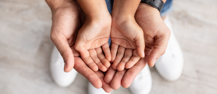 Child hands on top of adult hands, family law
