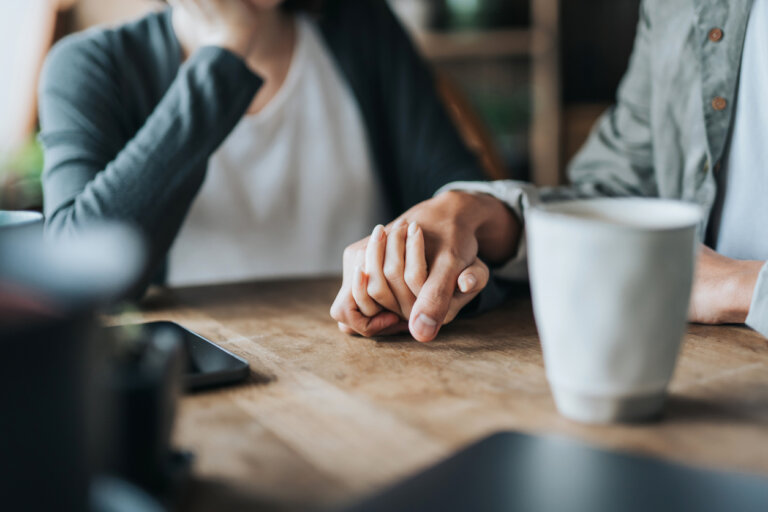 couple holding hands on table