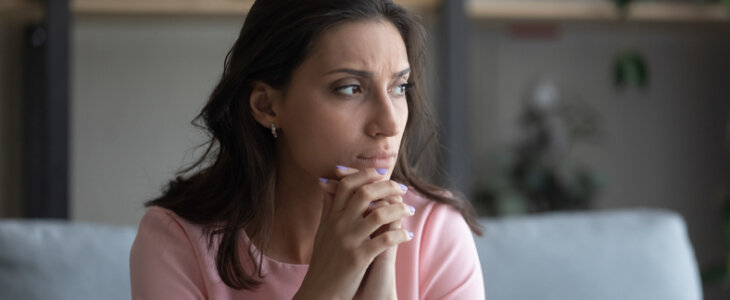 Young stressed mother sitting on a couch.