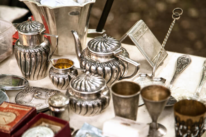 Old metal tableware collectibles at a garage sale.
