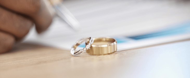 Rings placed beside paperwork, hinting at a legal or marriage-related process.