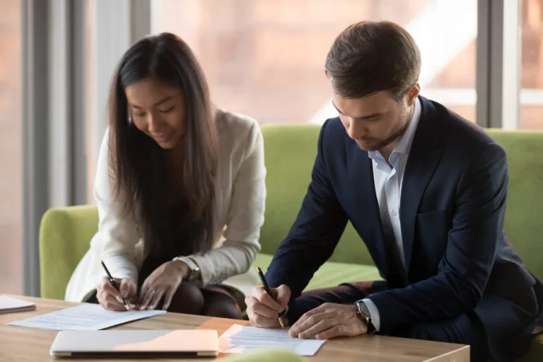 millennial couple signing a prenuptial agreement