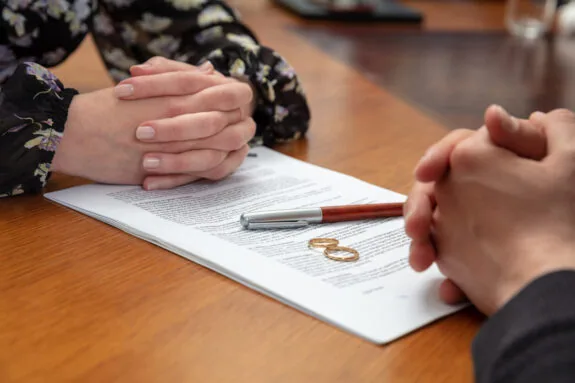 Two spouses signing a piece of divorce paper together